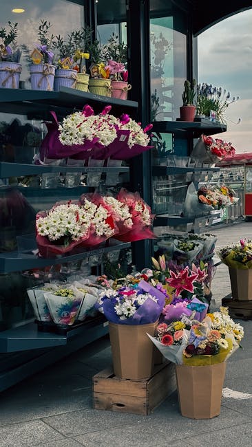A display of fresh floral arrangements at flowersharlow.co.uk, featuring vibrant bouquets wrapped in pink, purple, and brown paper, showcasing a variety of white, pink, purple, and yellow flowers such