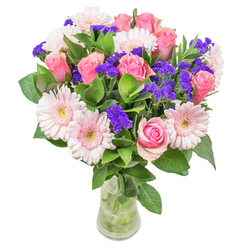 In the heart of Harlow, this bouquet comes to life as blush-pink gerberas and classic pink roses form a luminous, uplifting display, reminiscent of soft dawns over the tranquil gardens of Old Harlow. Their pastel hues blend in watercolor-like harmony, each petal a delicate brushstroke, while vibrant purple statice adds bold punctuation-like laughter on a bright spring morning. Crisp greenery fans out beneath, cool and moisture-rich, rooting the arrangement in a freshness echoing the lush walks of Parndon Wood. Arranged in a simple clear glass vase with water shimmering beneath, the bouquet seems to glow with an inner optimism, inviting a closer look and a sense of hope. Designed as a cheerful get-well offering for a loved one in Princess Alexandra Hospital, or as a sophisticated highlight for a modern living room in Church Langley, every aspect showcases a florist's discernment and joy in the details. The result: a bouquet that's both lighthearted and refined, carrying Harlow's welcoming spirit in every petal.
